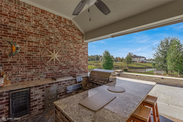 view of patio / terrace featuring ceiling fan, a grill, exterior kitchen, and wine cooler