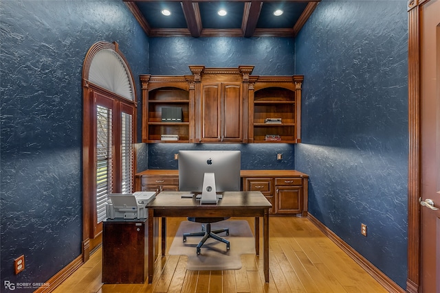 office featuring coffered ceiling, crown molding, beam ceiling, built in desk, and light hardwood / wood-style floors