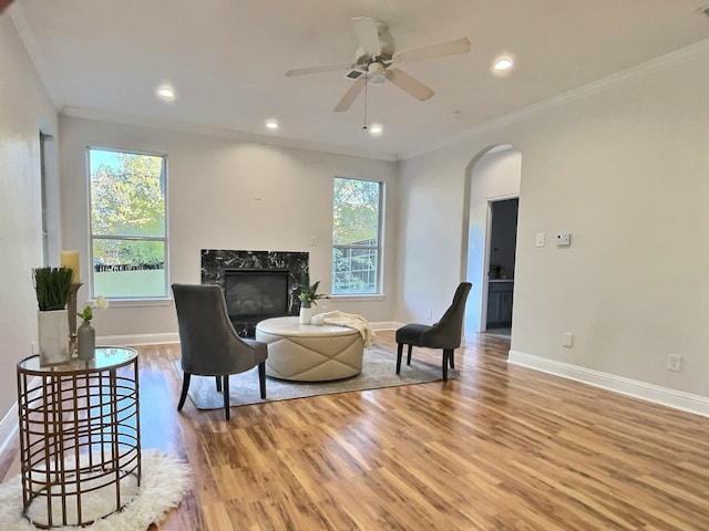 sitting room featuring a wealth of natural light, hardwood / wood-style floors, ceiling fan, and crown molding