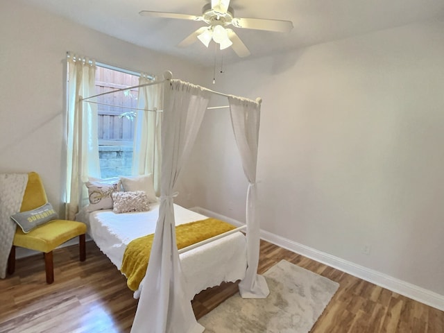 bedroom with multiple windows, hardwood / wood-style flooring, and ceiling fan