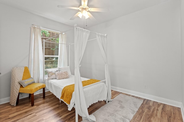 bedroom featuring ceiling fan, wood finished floors, and baseboards