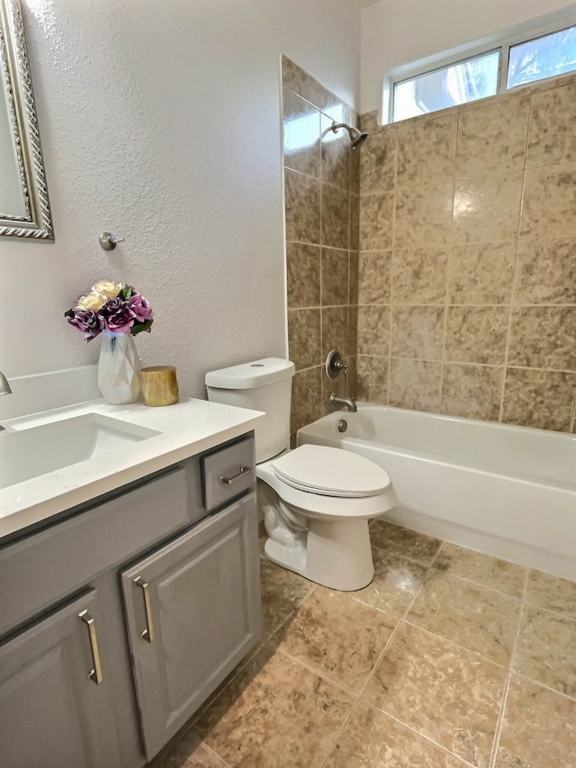 full bathroom with vanity, tiled shower / bath combo, and toilet