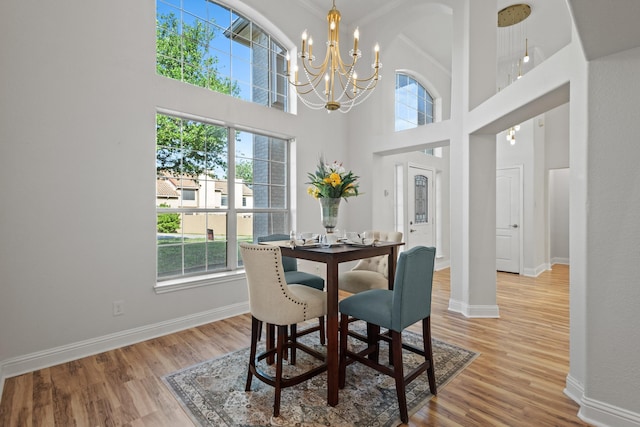 dining room with wood finished floors, a wealth of natural light, and an inviting chandelier