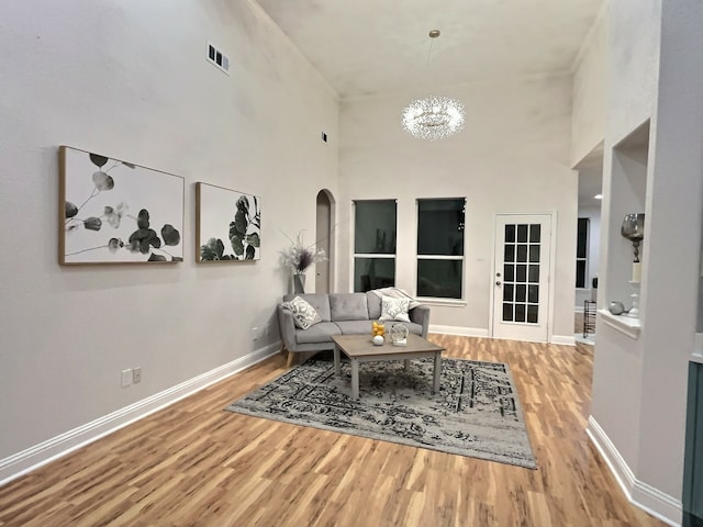 living room featuring a chandelier, a high ceiling, and hardwood / wood-style flooring