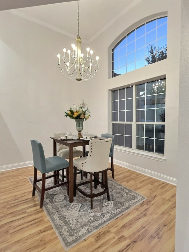 dining room with a chandelier, wood-type flooring, and ornamental molding