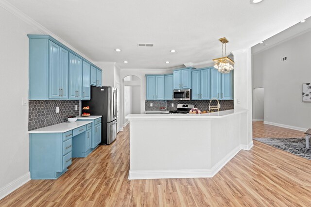 4224 Las Brisas Dr, Irving, TX 75038 - kitchen featuring tasteful backsplash, a sink, light wood-style floors, stainless steel appliances, and a peninsula