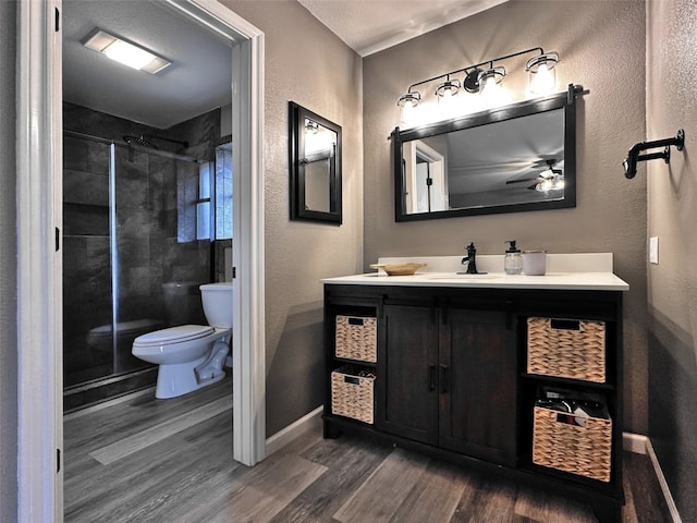 bathroom with hardwood / wood-style floors, vanity, toilet, and an enclosed shower