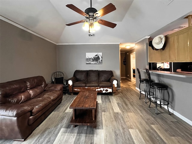 living room with hardwood / wood-style floors, ceiling fan, lofted ceiling, and ornamental molding