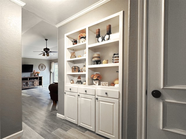 hallway featuring built in features, light hardwood / wood-style flooring, and crown molding