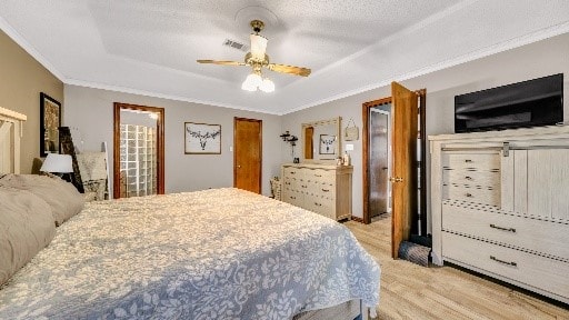 bedroom featuring ceiling fan, a textured ceiling, and ornamental molding