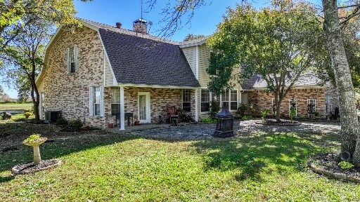 view of front of home with central AC and a front lawn