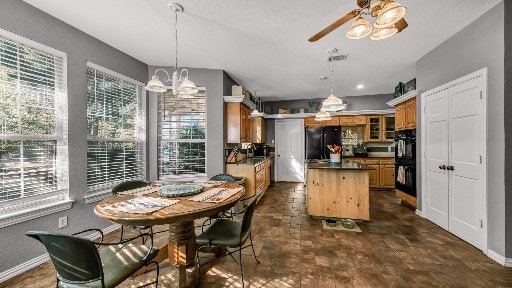 dining area featuring ceiling fan with notable chandelier