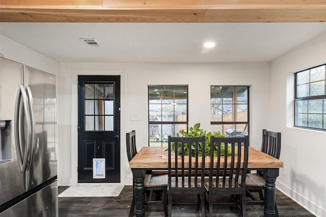 dining room with dark wood-type flooring and a healthy amount of sunlight