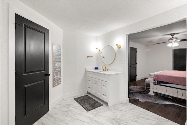 bathroom featuring hardwood / wood-style flooring, ceiling fan, a textured ceiling, and vanity