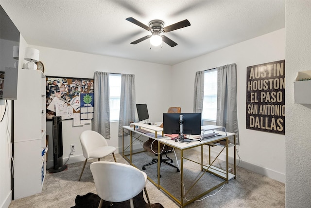 office with light colored carpet, ceiling fan, and a healthy amount of sunlight