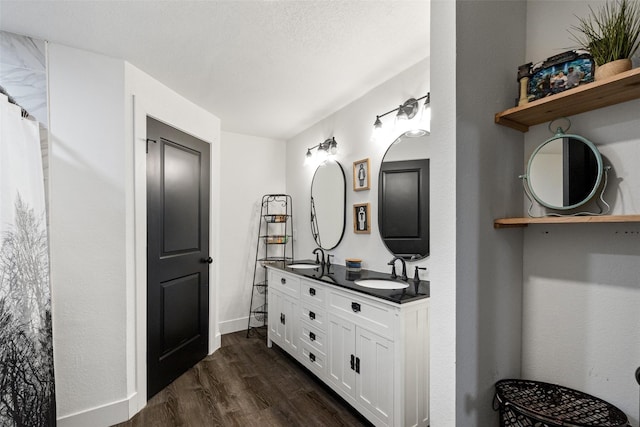 bathroom featuring wood-type flooring, vanity, and a textured ceiling