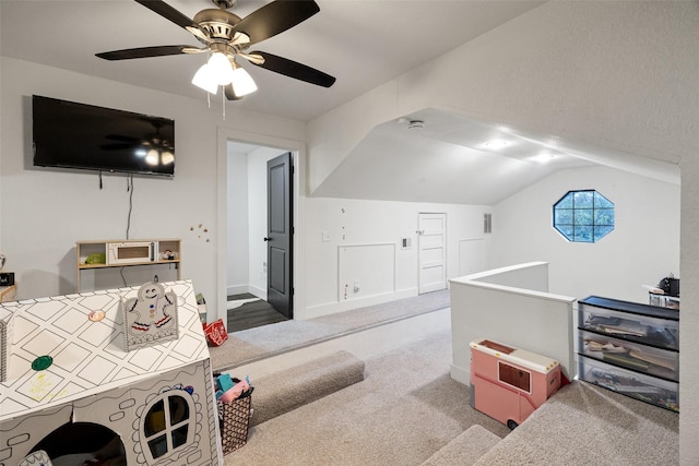 interior space with ceiling fan, lofted ceiling, and carpet floors