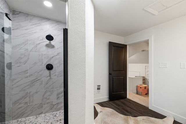 bathroom with hardwood / wood-style floors and tiled shower