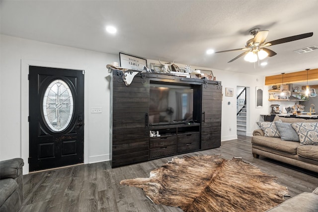 living room with dark hardwood / wood-style flooring and ceiling fan