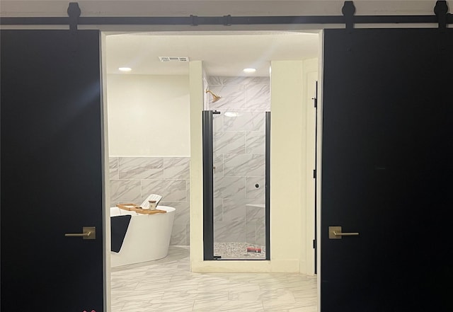 bathroom featuring tile walls and independent shower and bath