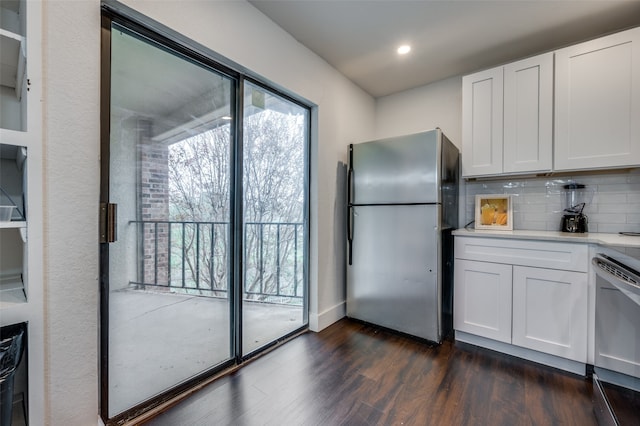 kitchen featuring tasteful backsplash, white cabinetry, dark hardwood / wood-style flooring, and appliances with stainless steel finishes