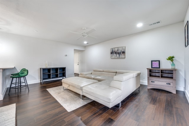 living room featuring ceiling fan and dark wood-type flooring