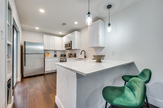 kitchen featuring white cabinets, appliances with stainless steel finishes, and backsplash