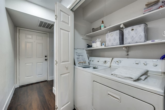 laundry room with dark hardwood / wood-style flooring and washing machine and clothes dryer