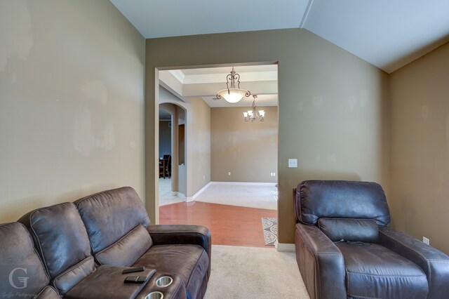 living room featuring light hardwood / wood-style floors, lofted ceiling, and an inviting chandelier