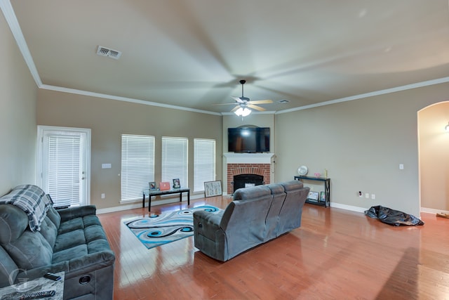 living room with light hardwood / wood-style floors, crown molding, and a fireplace