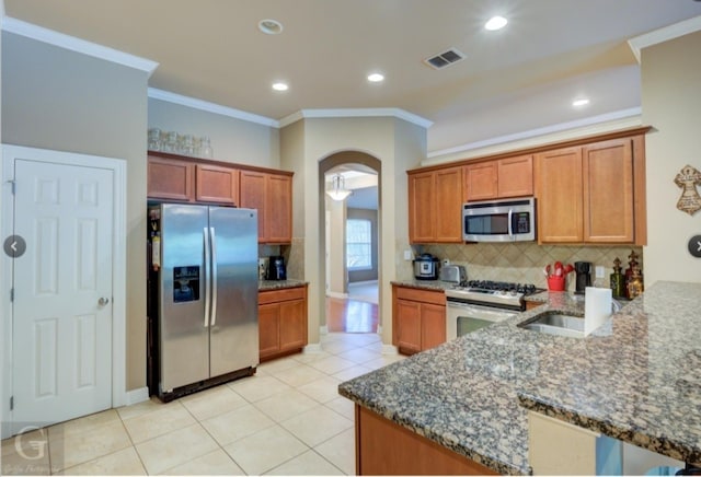 kitchen featuring dark stone counters, sink, crown molding, kitchen peninsula, and stainless steel appliances