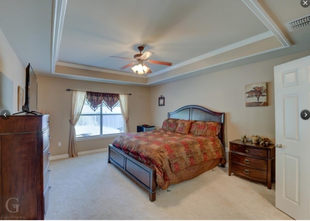 carpeted bedroom with a raised ceiling, ceiling fan, and crown molding