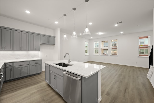 kitchen featuring pendant lighting, gray cabinets, stainless steel dishwasher, and sink