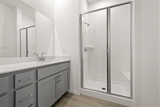 bathroom featuring vanity, an enclosed shower, and hardwood / wood-style flooring