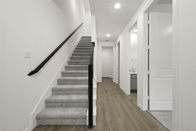 stairway with hardwood / wood-style floors