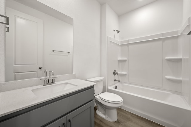 full bathroom with hardwood / wood-style flooring, vanity, shower / bathtub combination, and toilet