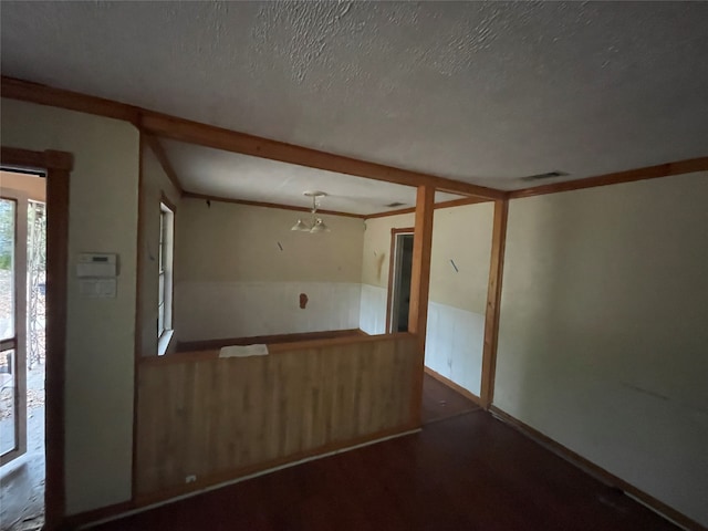 unfurnished room featuring a textured ceiling and crown molding