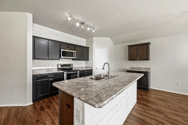 kitchen featuring sink, a textured ceiling, appliances with stainless steel finishes, an island with sink, and dark hardwood / wood-style flooring