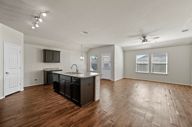 kitchen featuring dishwasher, dark hardwood / wood-style flooring, a kitchen island with sink, and sink