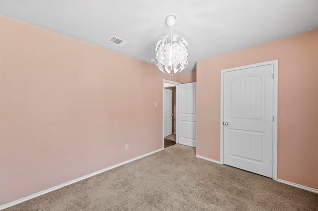 unfurnished bedroom featuring light carpet and an inviting chandelier