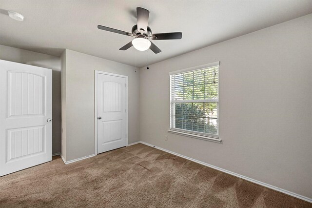 unfurnished bedroom featuring carpet floors and ceiling fan