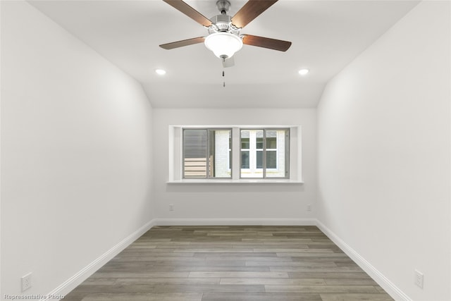 spare room with ceiling fan, wood-type flooring, and vaulted ceiling