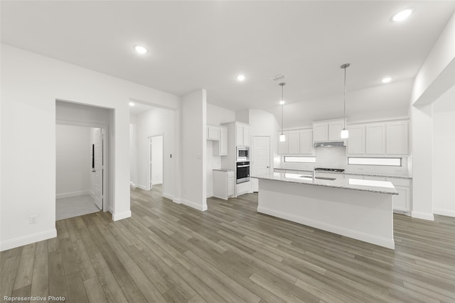 kitchen featuring white cabinetry, a center island with sink, and wood-type flooring