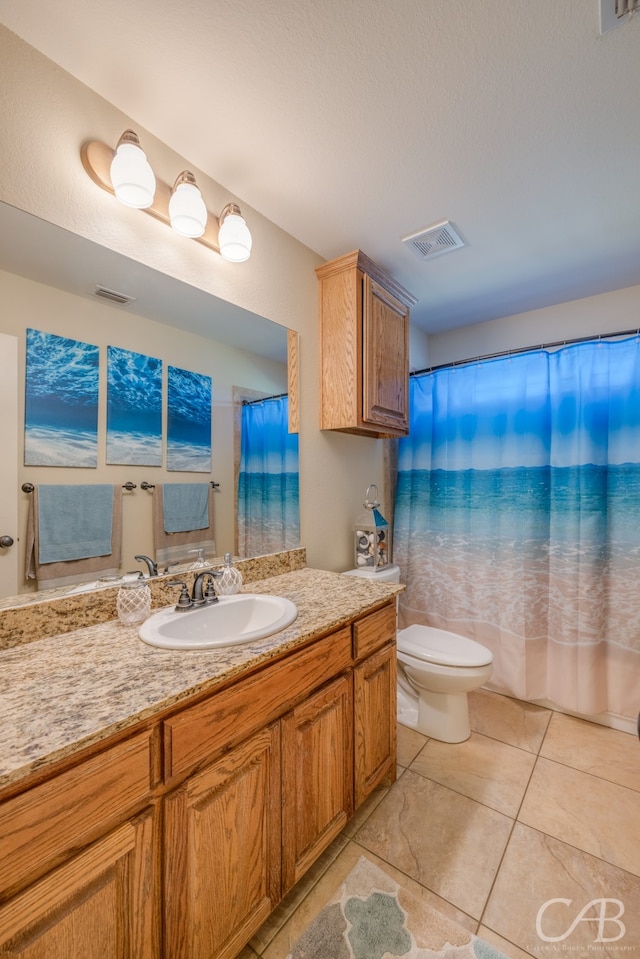 bathroom featuring tile patterned floors, vanity, toilet, and walk in shower