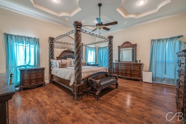 bedroom featuring ornamental molding, dark wood-type flooring, and a tray ceiling