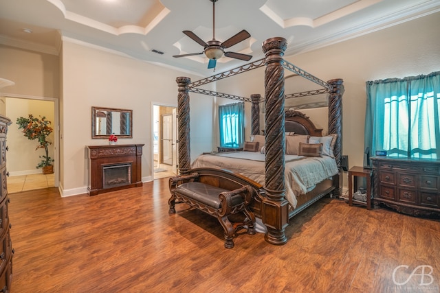 bedroom featuring wood-type flooring, ensuite bath, and crown molding