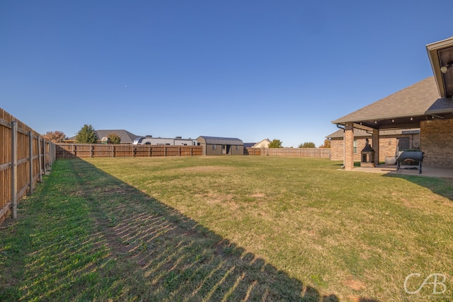 view of yard featuring a storage shed and a patio