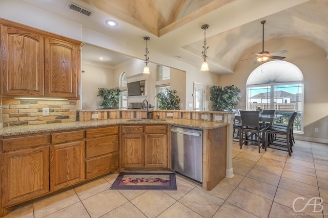 kitchen featuring sink, stainless steel dishwasher, decorative backsplash, light stone countertops, and decorative light fixtures