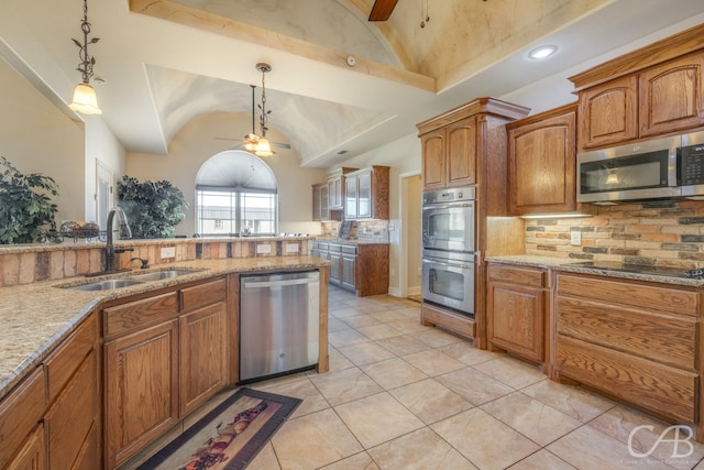 kitchen with sink, stainless steel appliances, hanging light fixtures, and vaulted ceiling