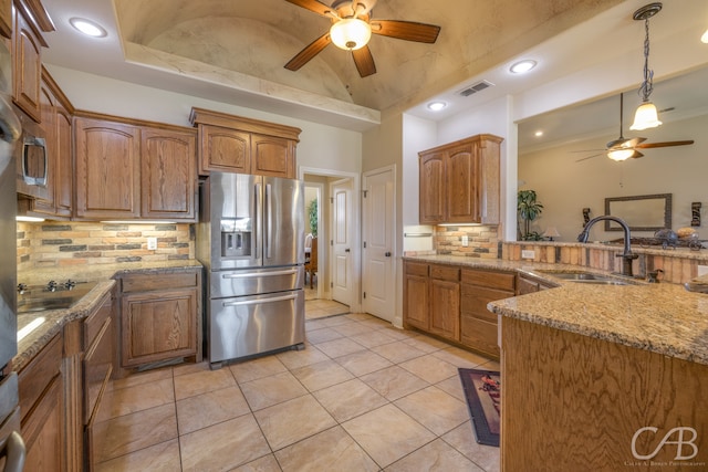 kitchen featuring backsplash, sink, stainless steel refrigerator with ice dispenser, light stone countertops, and light tile patterned flooring